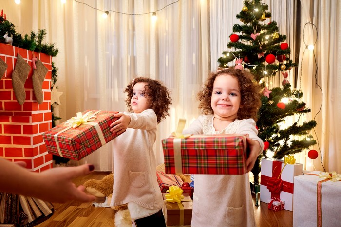 Two little girls giving Christmas gifts