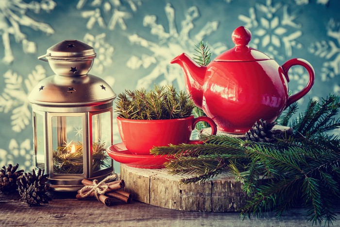 Christmas still life with red teapot, lantern, and cinnamon