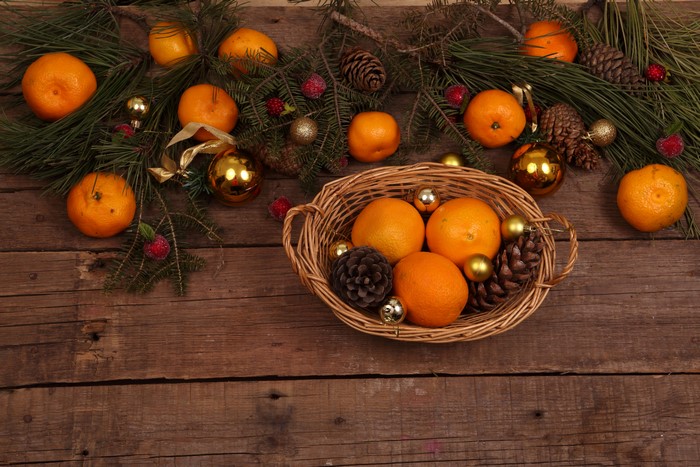 Christmas oranges and pine cones on wood