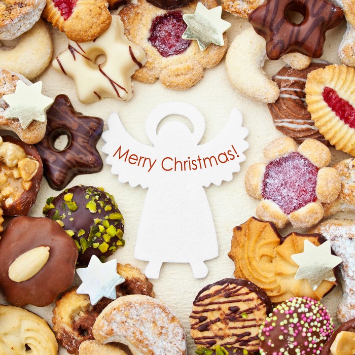 Christmas cookies arranged around a Merry Christmas angel decoration