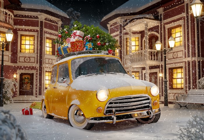 Yellow car with Christmas tree and gifts in snowy town