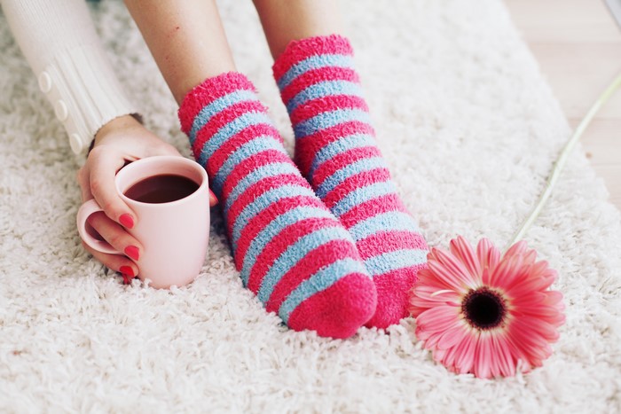 Person in striped socks holding hot chocolate