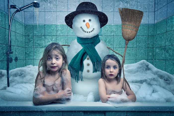 Two little girls and a snowman in a bathtub