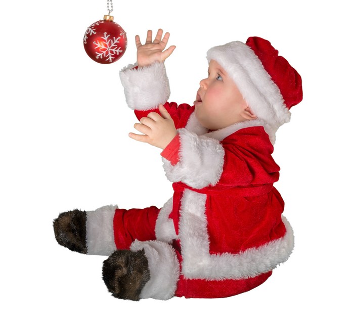 Baby in Santa Claus uniform reaching for ornament