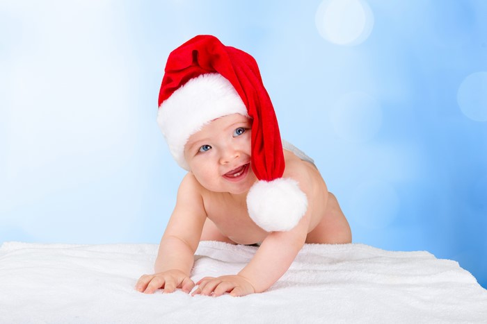 Baby in Santa hat on white blanket