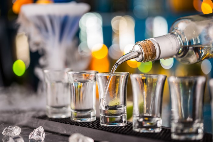 Vodka being poured into shot glasses