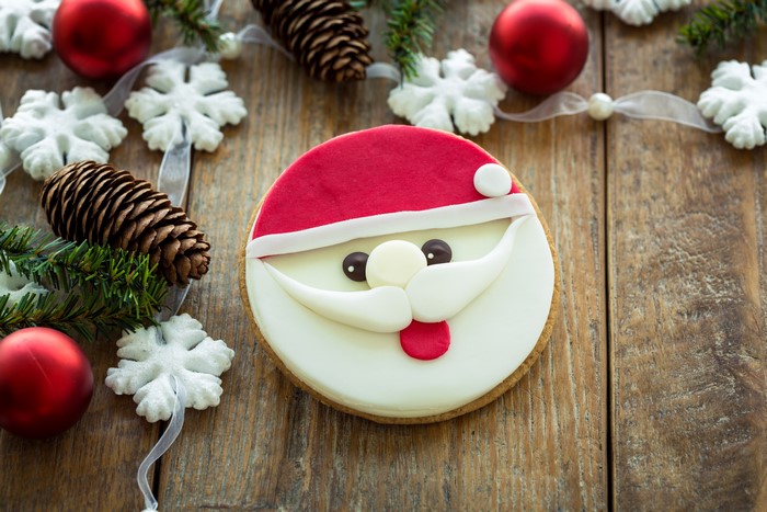 Santa Claus cookie with Christmas decorations on wood