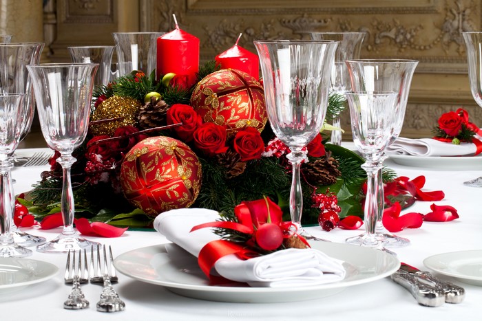 Christmas table setting with red ornaments and candles