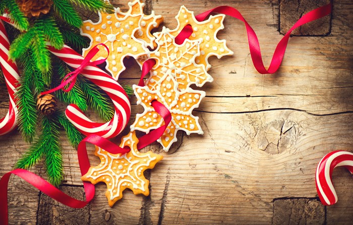 Christmas cookies, candy canes, and pine branches on wood