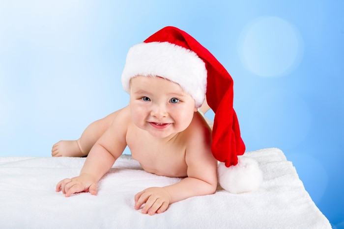 Baby in Santa hat on white blanket