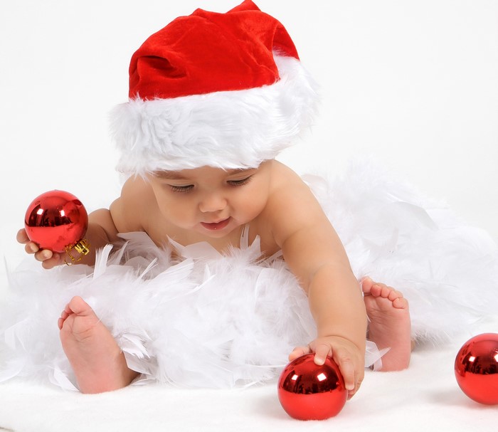 Baby in Santa hat with Christmas ornaments