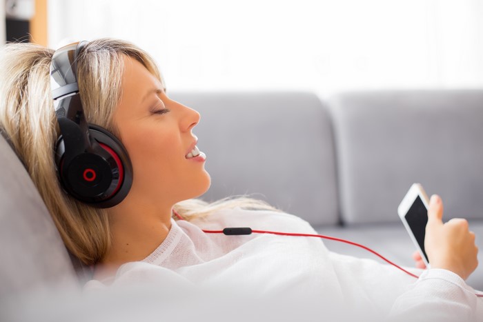 Blonde girl listening to music with headphones