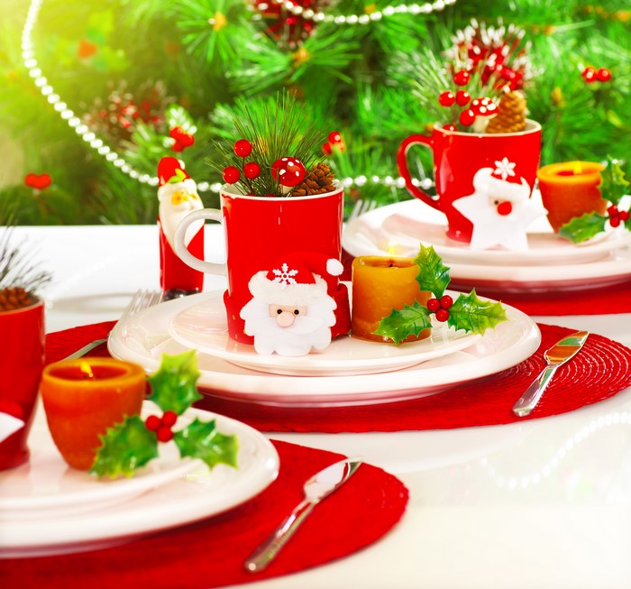 Christmas table setting with Santa Claus mugs and candles