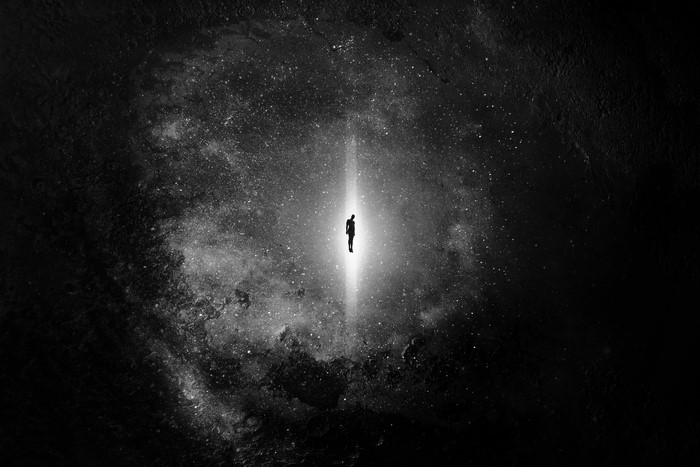 Silhouette of a person in a beam of light in space
