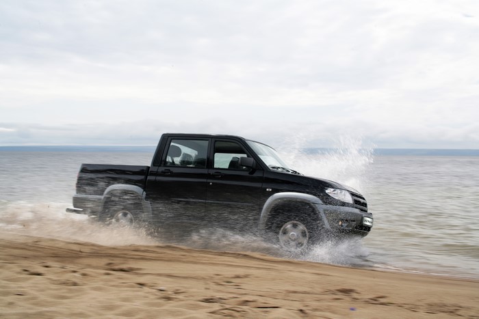 Black UAZ Patriot Off-Road 4x4 Driving on a Beach