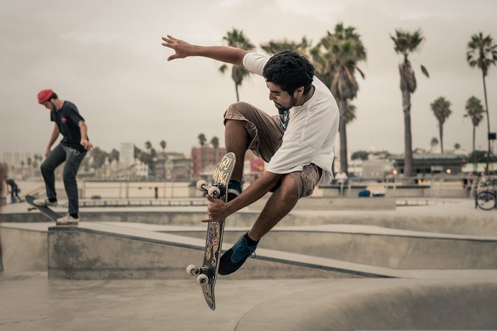 Men skateboarding and jumping at a skatepark