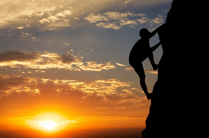 4K Climber Silhouette Against Vibrant Sunset Sky