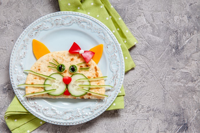 Cat-shaped pancake with vegetables on a plate