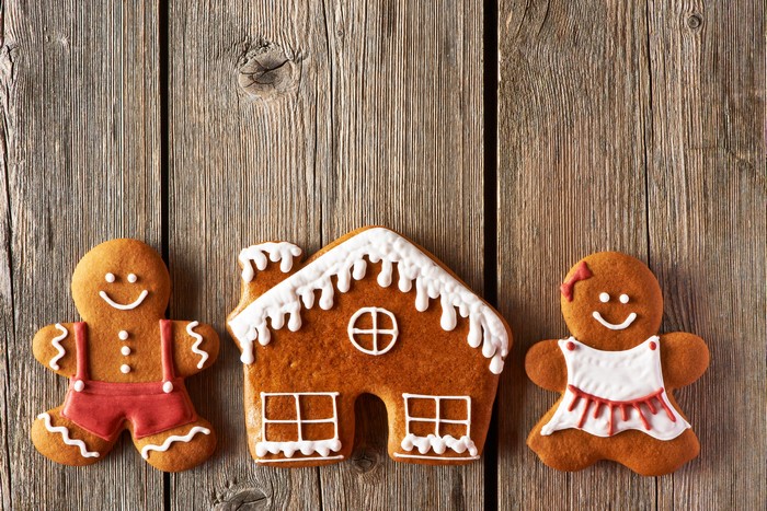 Gingerbread man, woman, and house on wood
