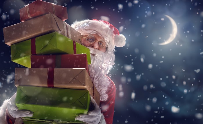 Santa Claus carrying gifts at night with a crescent moon
