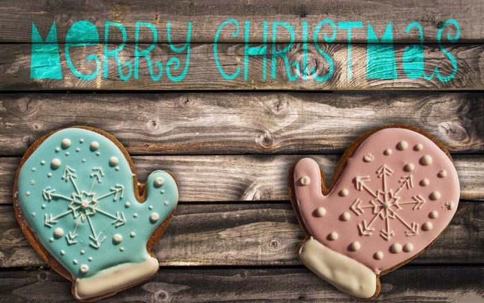 Merry Christmas text with mitten cookies on wood
