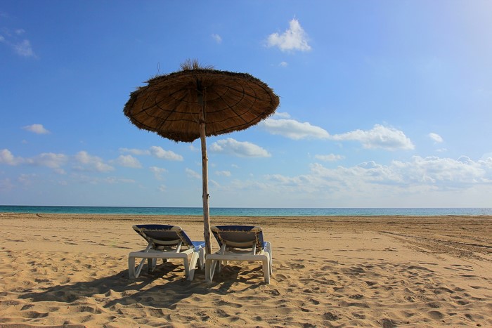 Beach umbrella and sunloungers on a sandy beach