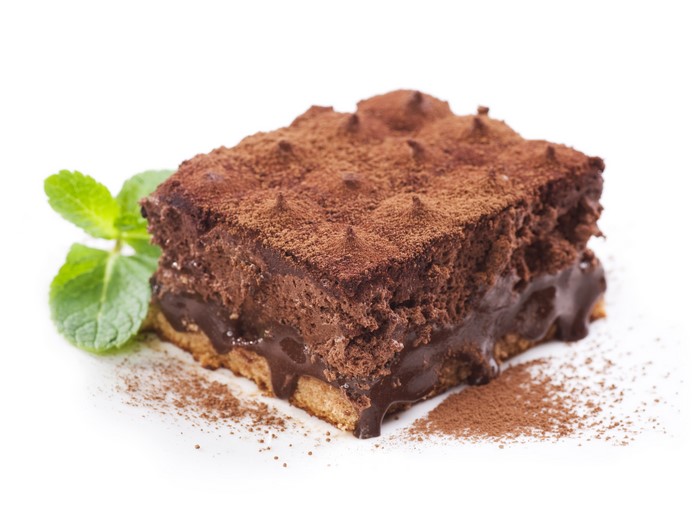 Chocolate cake slice with cocoa powder and mint