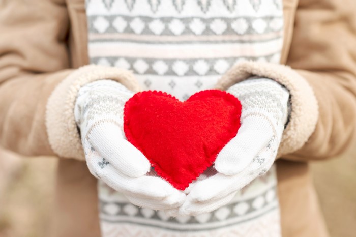 Hands in Gloves Holding a Red Heart