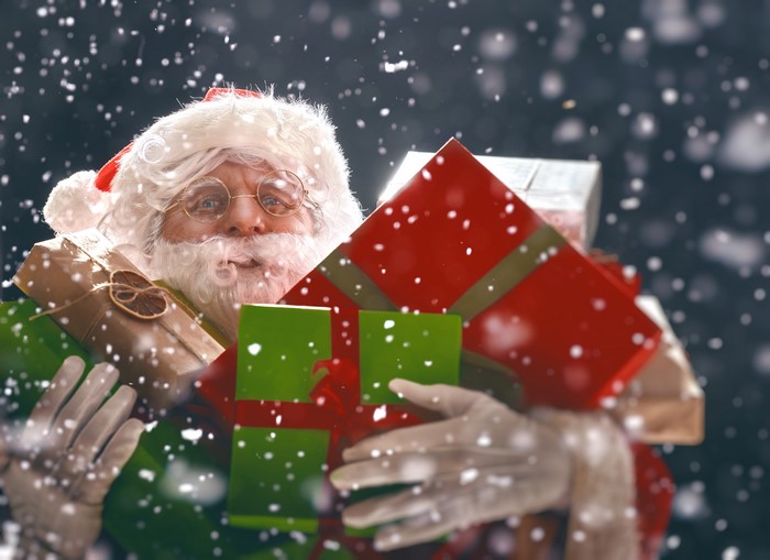 4K Santa Claus holding gifts with snowflakes