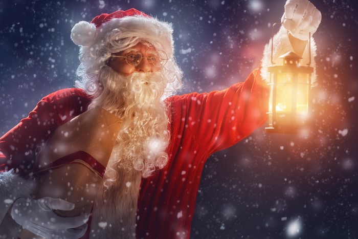 Santa Claus holding a lantern and a letter