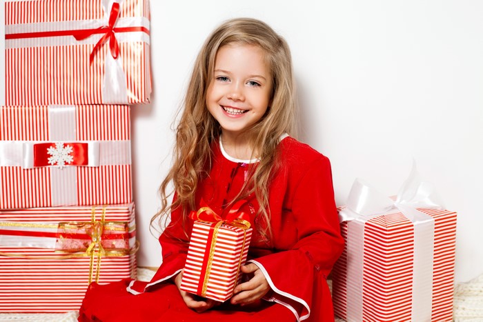 Little girl with blonde hair and Christmas gifts
