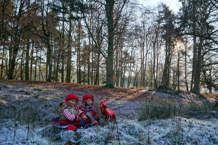 Two dolls and a deer in a frosty park