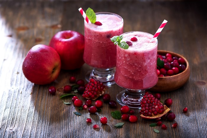 Two glasses of berry smoothie with apples and pomegranate