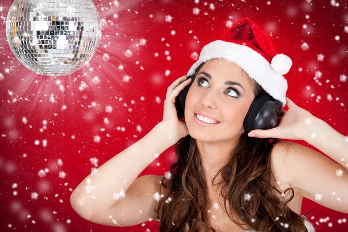 Woman in Santa hat listening to music with headphones