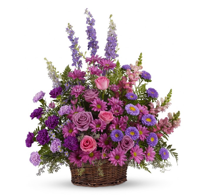 Purple and pink flower arrangement in a wicker basket