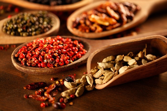Various spices in wooden spoons