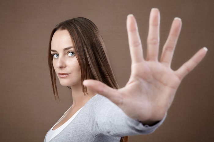 Woman holding up hand in stop gesture