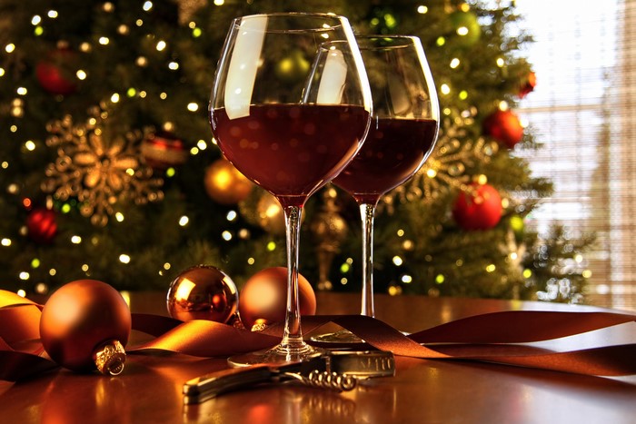 Two glasses of red wine with Christmas tree and ornaments