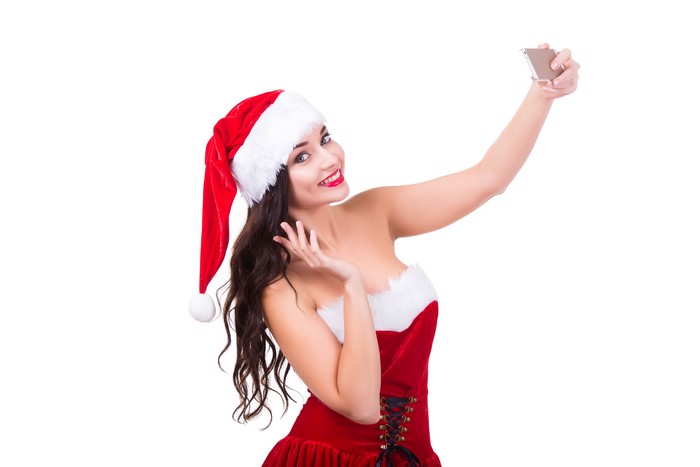 Woman in Santa hat taking a selfie