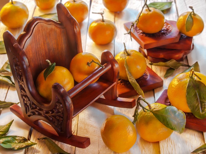 Tangerines in a wooden sleigh with leaves