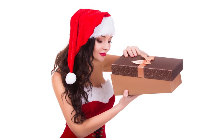 Woman in Santa hat holding Christmas gifts