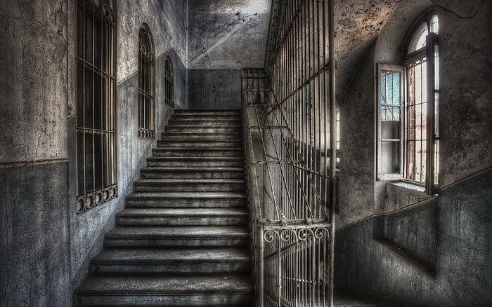 Abandoned building interior with stairs and windows