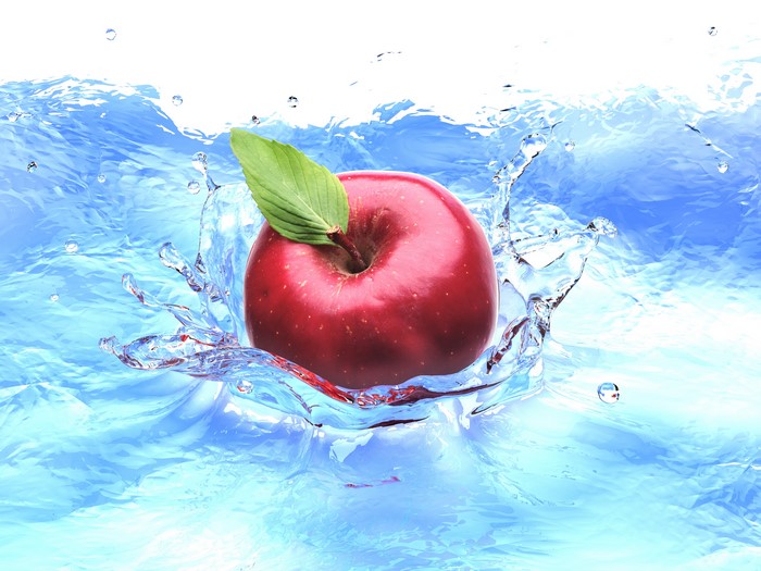 Red apple splashing into water