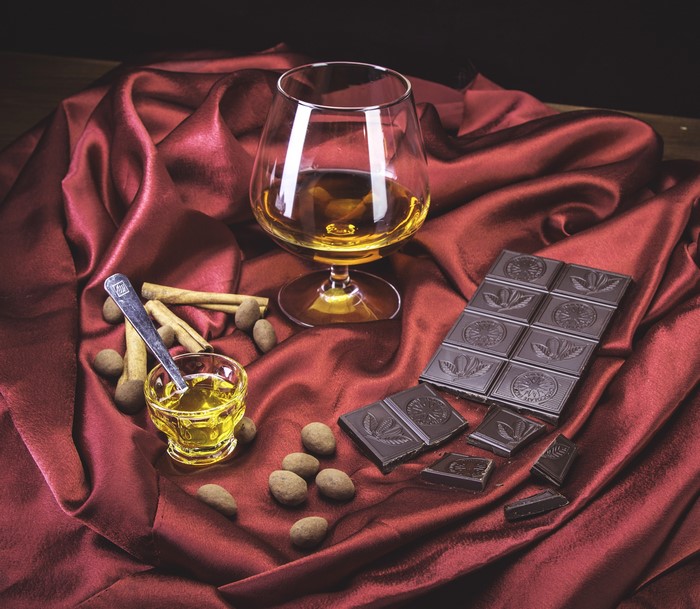 Whisky, chocolate, cinnamon, and almonds on red satin
