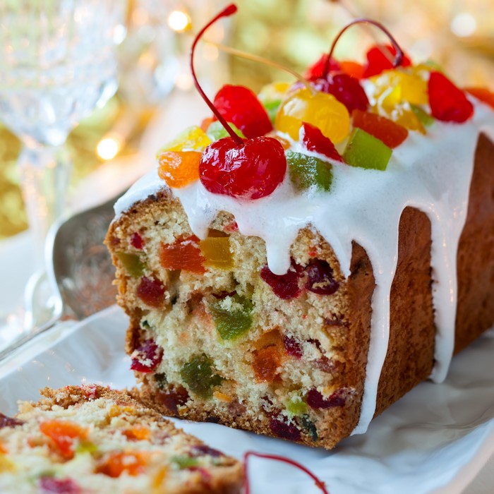 Fruitcake with white icing and cherries