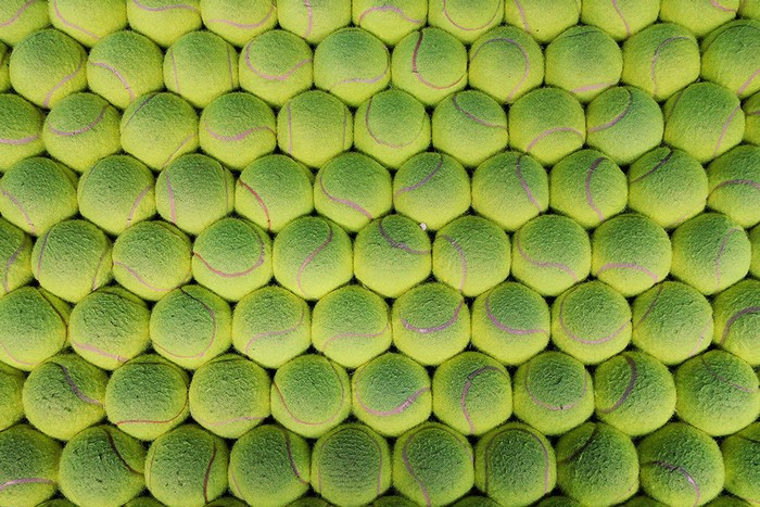 A wall of bright green tennis balls