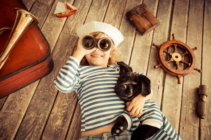 Girl in sailor outfit with dog and nautical props
