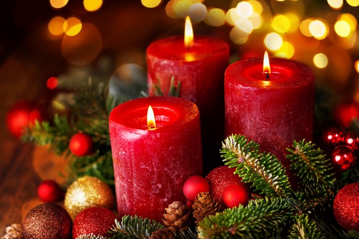 Three red candles with Christmas decorations