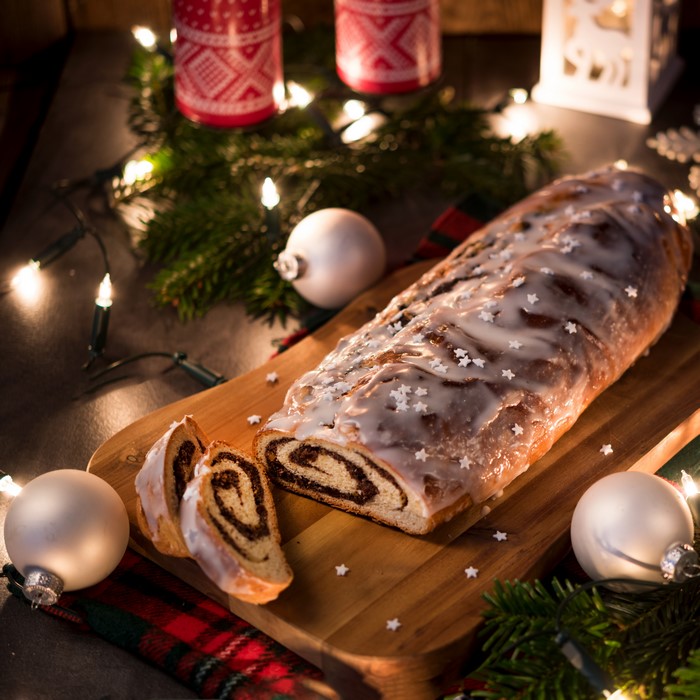 Christmas poppy seed roll on a cutting board with decorations