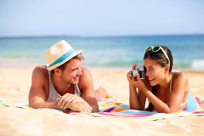 Couple taking photos on a beach